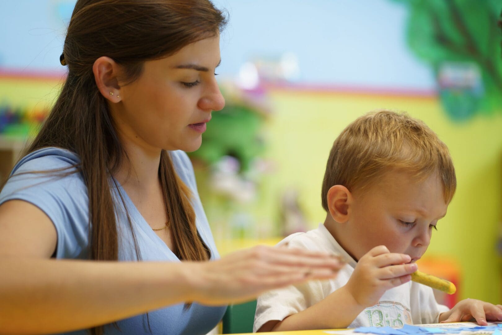 Instructor guiding child with creative activity.