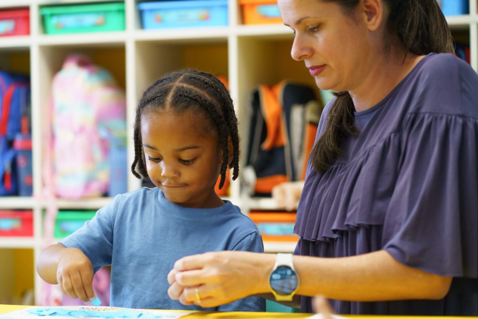 Child focused on activity with adult guidance.