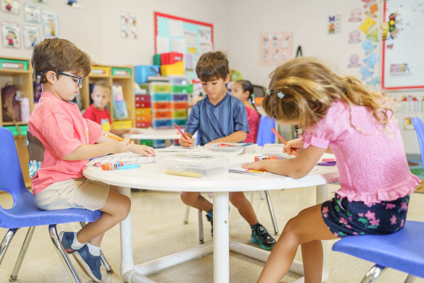 Children coloring and crafting at classroom tables.