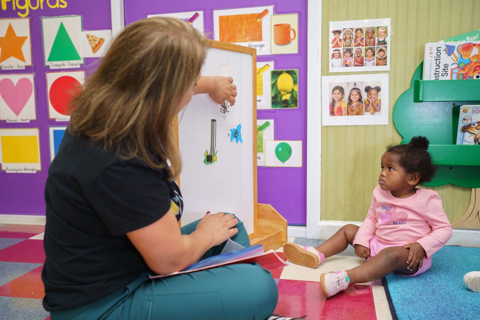 Instructor demonstrating activities to attentive child.