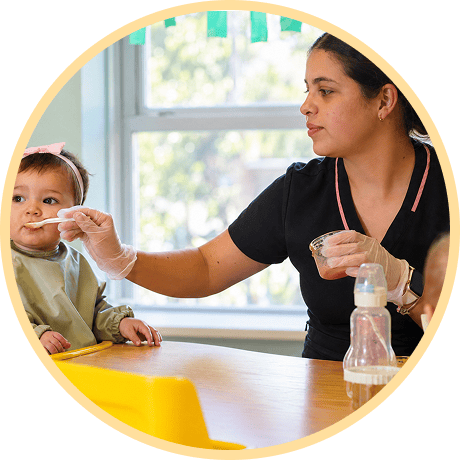 Caregiver feeding a child with spoon