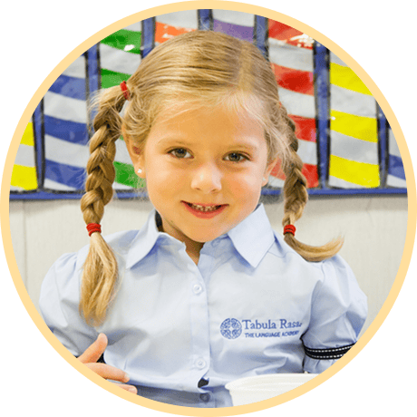 Smiling girl in blue shirt at school.