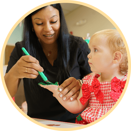 Adult assisting child with hand painting