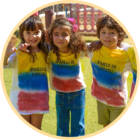 Three children wearing colorful shirts outdoors.