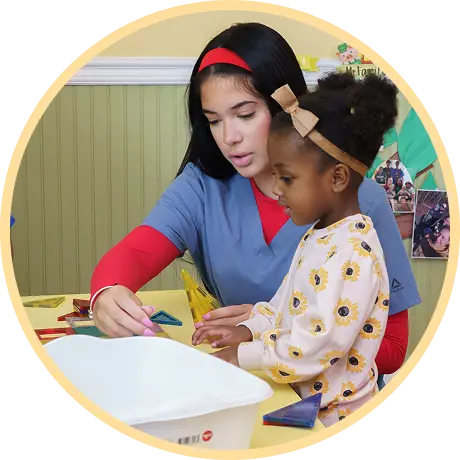 Instructor guiding child with colorful shapes.